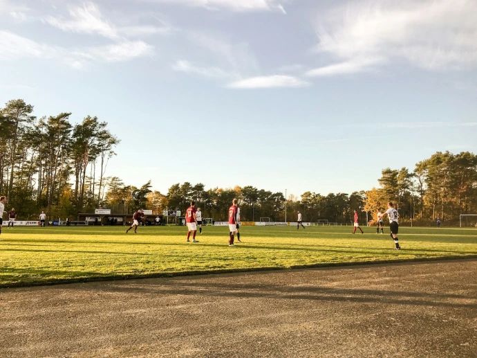 landscape photography of people playing soccer on field during daytime
